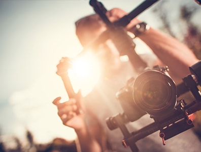 Cameraman de Visuel Films en tournage avec un boitier numérique et un stabilisateur
